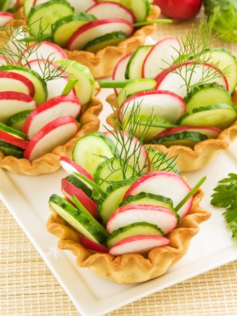Group of the vegetable tartlets on wooden background. Shallow dof.の写真素材
