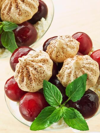 Glasses with dessert of cottage cheese, plums, meringue and mint. Shallow dof.の写真素材