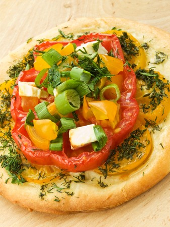 Mini focaccia with tomatoes, feta cheese and herbs. Shallow dof.
の写真素材