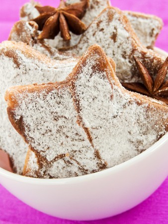 Bowl with chocolate cookies with powdered sugar and anise. Shallow dof.の写真素材