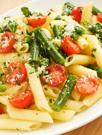 Italian pasta penne with cherry tomatoes and green beans. Shallow dof.の写真素材