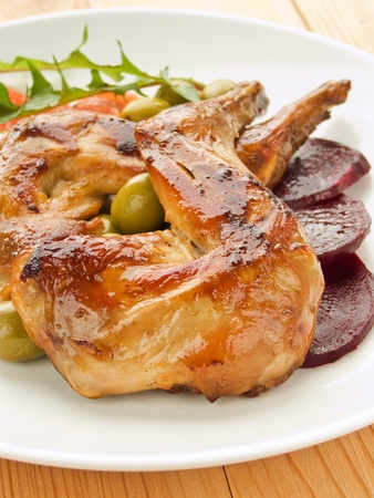 Plate with roasted rabbit legs and vegetable garnish. Shallow dof.の写真素材