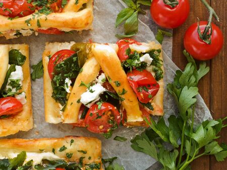 Homemade tart slices with cottage cheese, herbs and cherry tomatoes. Viewed from above.の写真素材