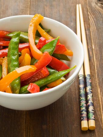 Bowl with green peas and bell pepper stir-fry. Shallow dof.の写真素材