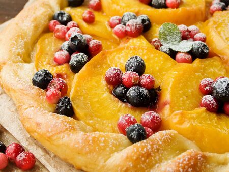 Homemade tart with peaches and berries. Shallow dof.の写真素材