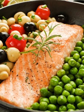Frying pan with salmon steak, stir-fry veggies and herbs, Shallow dof.の写真素材