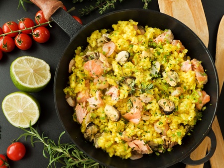 Frying pan with seafood paella and herbs. Viewed from above.の写真素材