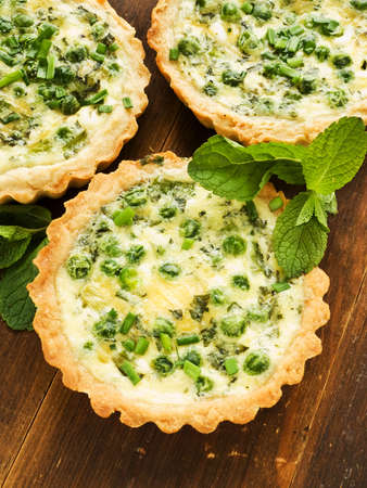Tartlets with green peas, cheese, eggs and mint. Shallow dof. 