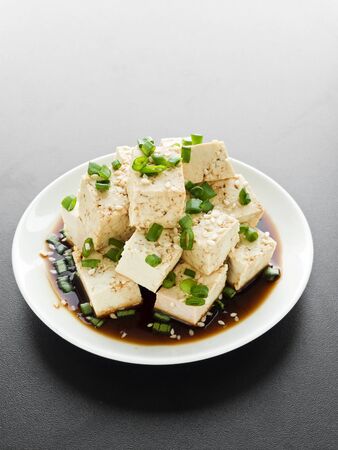 Plate with tofu cheese in soy sauce with green onion. Shallow dof.の写真素材