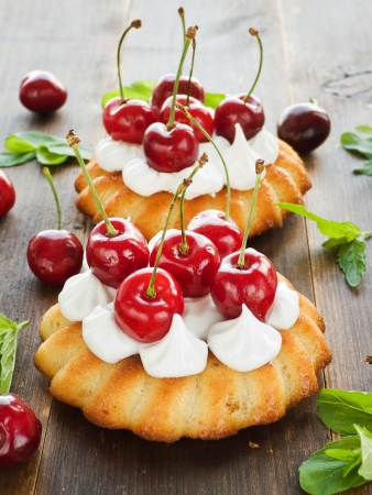 Coconut cakes with whipped cream and sweet cherry. の写真素材
