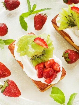 Coconut cakes with whipped cream, strawberry and kiwi. の写真素材