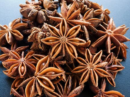 A group of anise stars on the black background. Shallow dof.