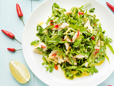 Salad with steamed sea bass fillet, chili pepper, rucola, cilantro and ginger in olive and linseed oil  Shallow dof の写真素材
