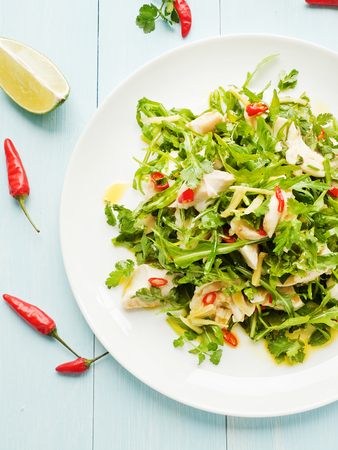 Salad with steamed sea bass fillet, chili pepper, rucola, cilantro and ginger in olive and linseed oil.の写真素材