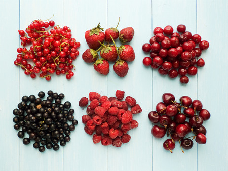 Different kinds of berries on the blue background  Viewed from above 