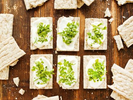 Small whole wheat bread snacks on the wooden background. Shallow dof.