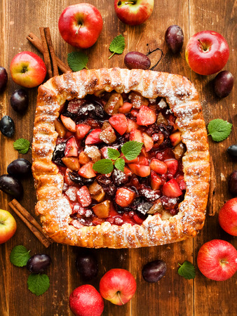 Sweet apple plum pie on the wooden background. Shallow dof.の写真素材