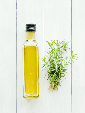 Fresh rosemary and olive oil on wooden background. Shallow dof.の写真素材
