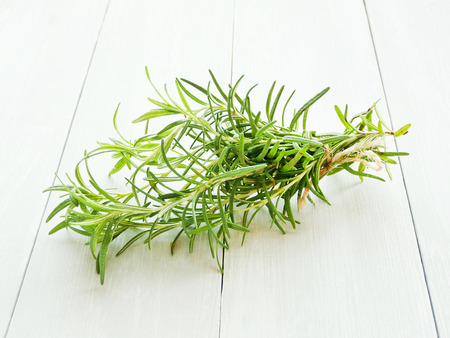 Fresh rosemary on wooden background. Shallow dof.の写真素材
