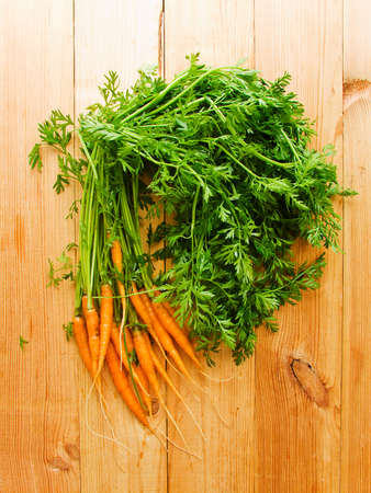 Fresh baby carrots on the wooden background. Shallow dof.