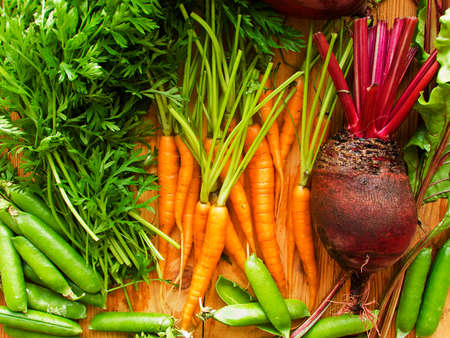 Beetroots, carrots and green peas wooden background. Shallow dof.の写真素材