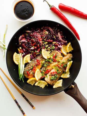 Baked hake fish with herbs and spices, soy sauce.