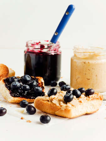 White bread toasts with blueberry jam and peanut butter. Shallow dof.