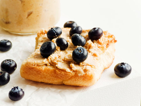 White bread toast with peanut butter and blueberries. Shallow dof.