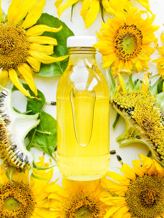 A bottle of sunflower oil and flowers on the white. Shallow dof.の写真素材