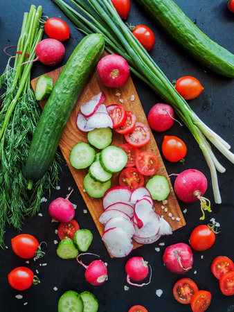 Seasonal diet and nutrition, healthy eating. Red cherry tomatoes, radish, herbs and cucumbers...