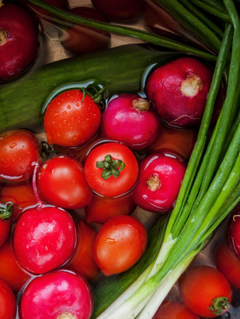 Seasonal diet and nutrition, healthy eating concept. Bunch of fresh vegetables rinsed in the bowl with water in the sink, close up of veggies in the bowl covered with water drops.の写真素材