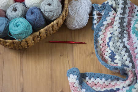 colorful woolen balls with crochet hook and handmade blanketの写真素材