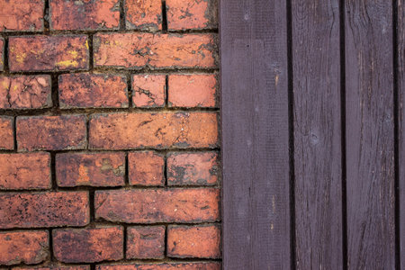 dark brown wooden wall and red brick stone house wall backgroundの写真素材