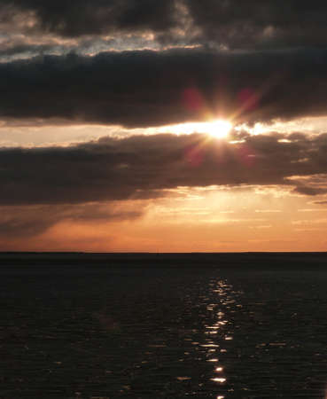 sunset abova a frozen baltic sea with reflections on iceの写真素材