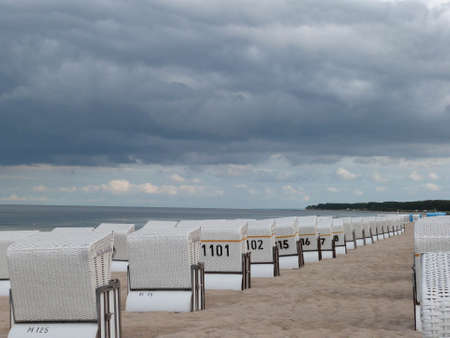 white beach chairs standing in a row at a baltic sea beachの写真素材