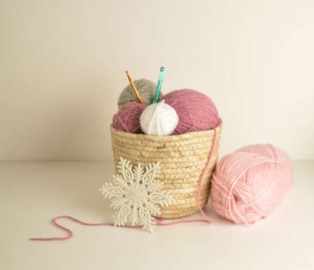 pastel colored woolen balls in basket with crochet hooks for handicraftsの写真素材