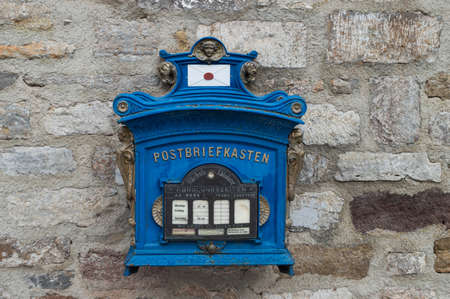 blue old postbox on old rustic stone wall backgroundの写真素材