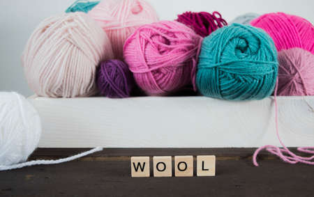 colorful woolen balls on dark brown wooden ground for handicrafts handmadeの写真素材