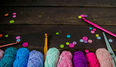 colorful woolen balls on dark brown wooden ground for handicrafts handmadeの写真素材