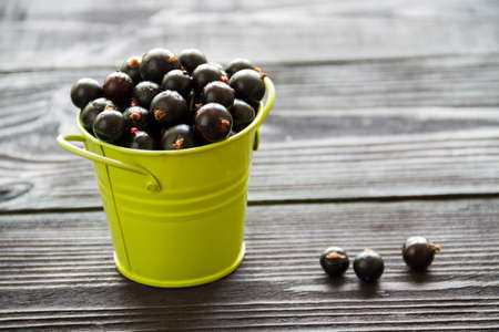 fresh sweet blackcurrants in the bowl on wooden backgroundの写真素材