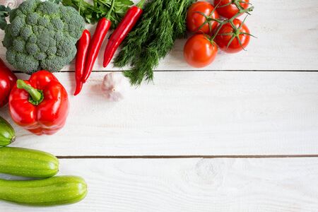 fresh vegetables on wood background, small tomatoes, pepper, chilli, zucchini and broccoli, and others, top view, space for textの写真素材