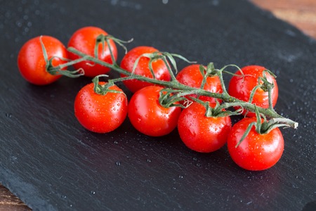 fresh, ripe small tomatoes on wood backgroundの写真素材