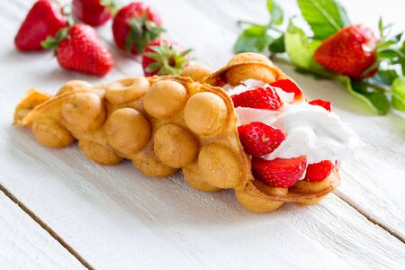 Hong Kong waffles with strawberries and whipped creamの写真素材