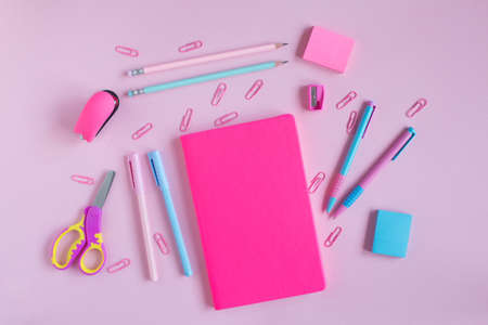 School notebook and stationery on a pink background.の写真素材