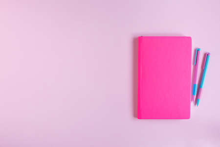 School notebook and stationery on a pink background.の写真素材
