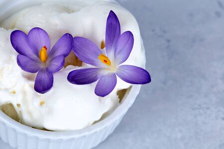 Vanilla ice cream decorated with purple flowers.の写真素材