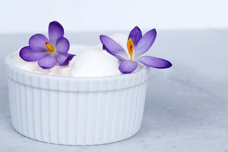 Vanilla ice cream decorated with purple flowers.の写真素材