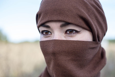 A woman in a burqa looks into the distance. A woman in a hijab. A day of hijab and chastityの写真素材