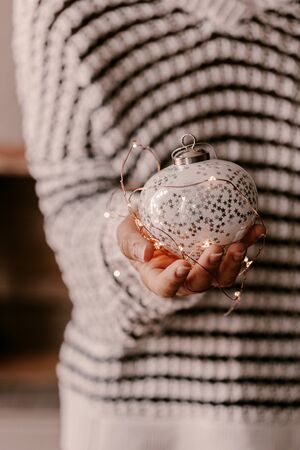 Vintage Christmas tree ornament in woman hands. Christmas mood and atmosphere. Blurred photos, bokeh.の写真素材