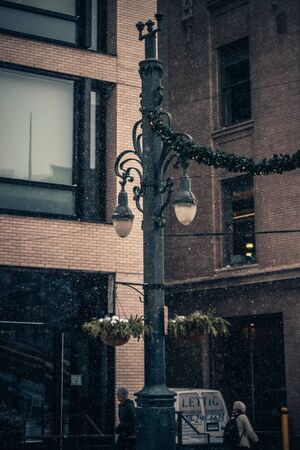 New Year's Eve snowing day in the city. Showing in the streets of Downtown. Snowy city streets